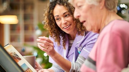 young woman and older woman look at magazine together