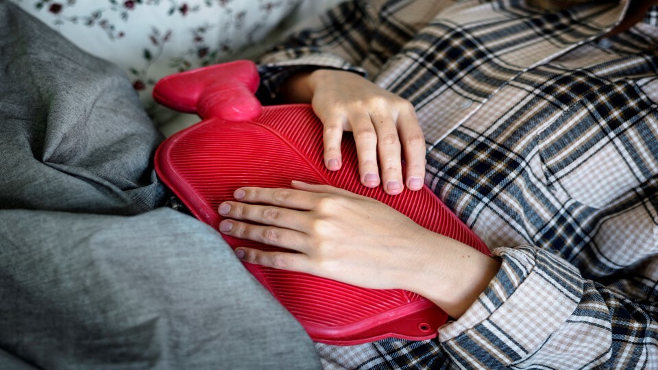 Person holds a water bottle to their stomach