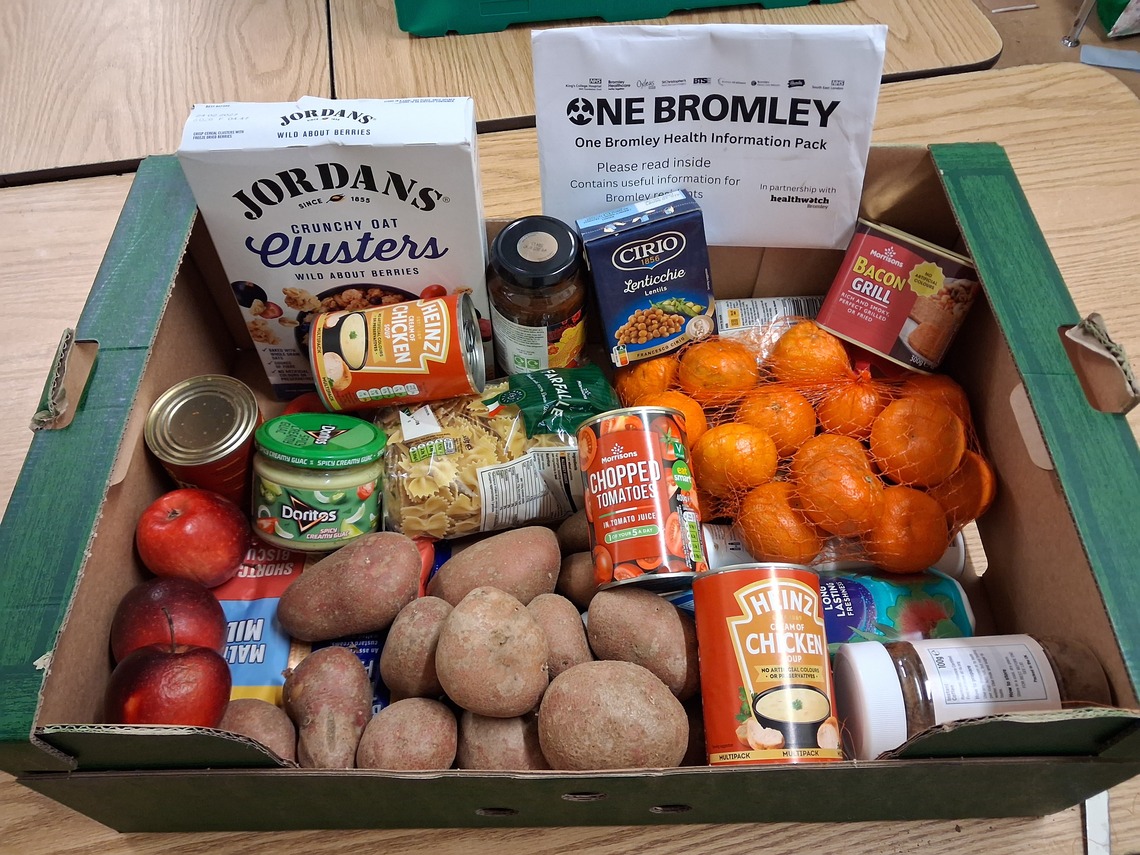 box full of a range of foods along with an envelope tucked in with health information in it