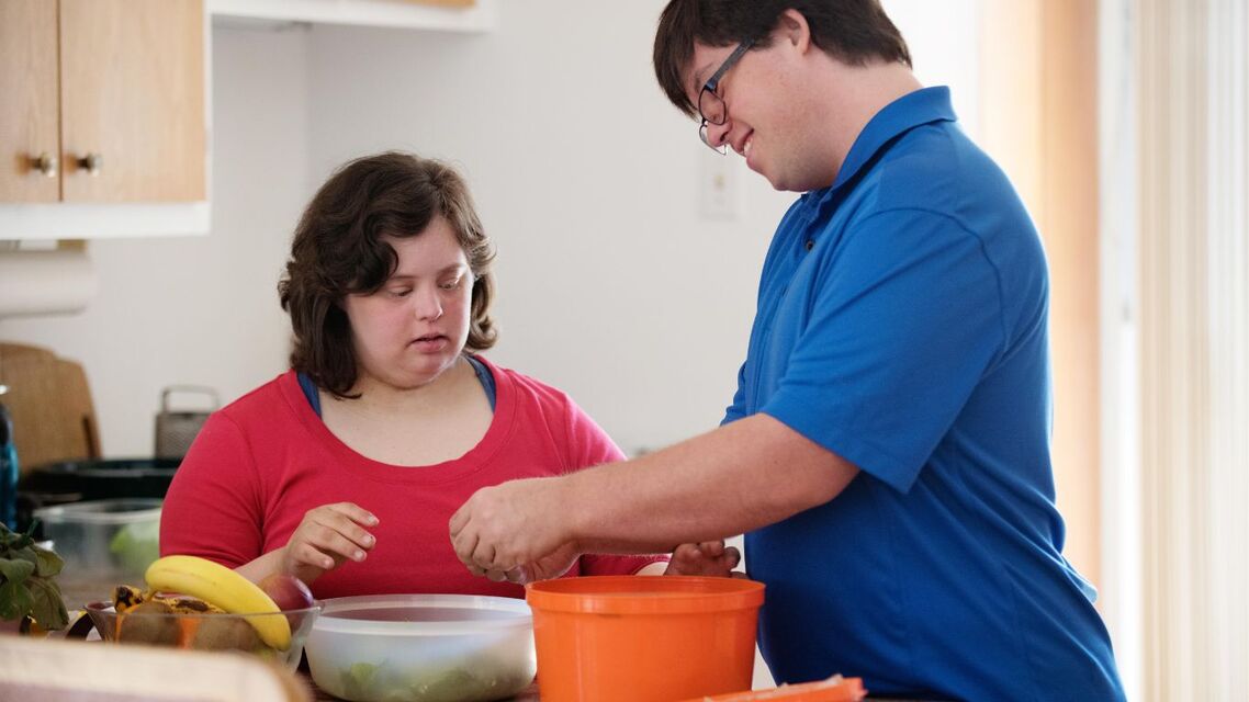2 young people with learning disabilities preparing food