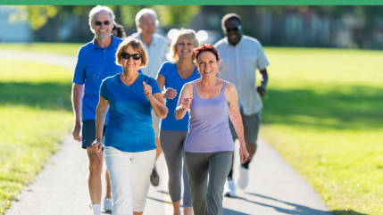 small group of older people walking in park