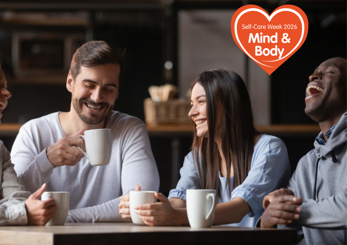 4 people laughing whilst enjoying a cup of coffee in cafe