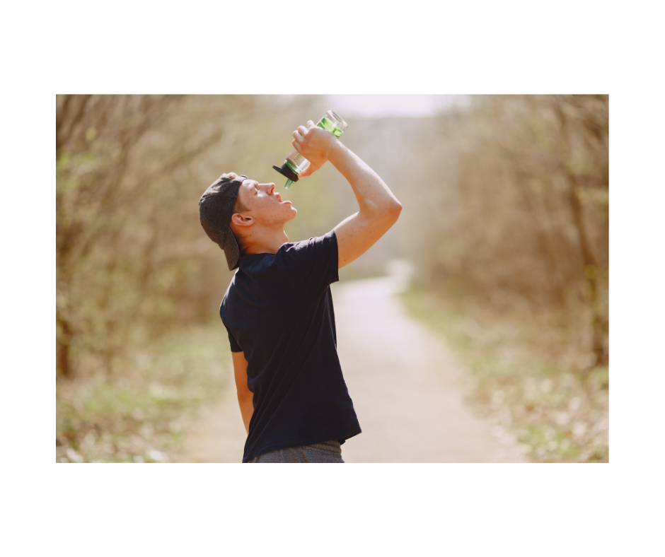 man with baseball cap drinking water on hot day