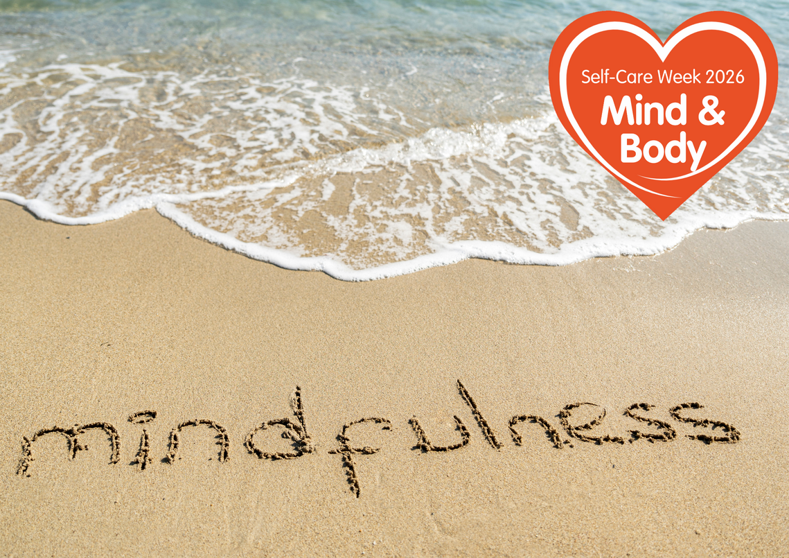 mindfulness written in sand at seafront