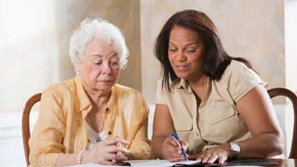 young woman explains paperwork to older woman