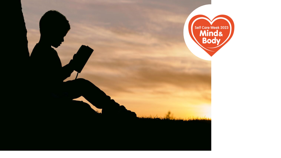 silhoutte of a child, sitting side on reading a book