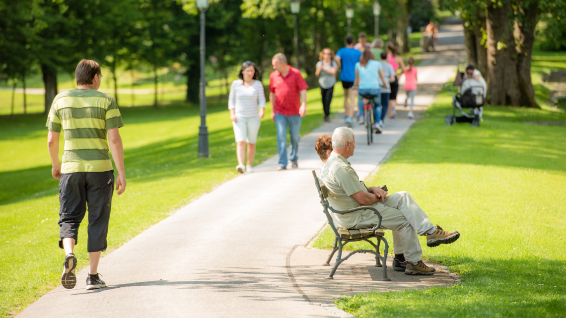 people walking through a city park