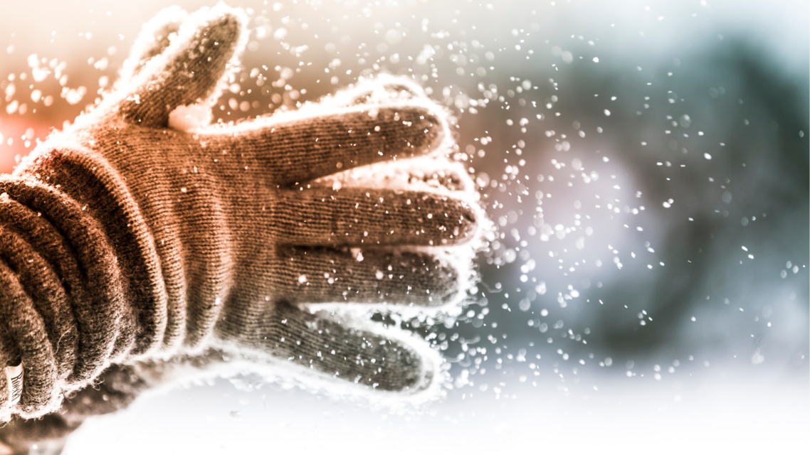gloved hands with snowy background