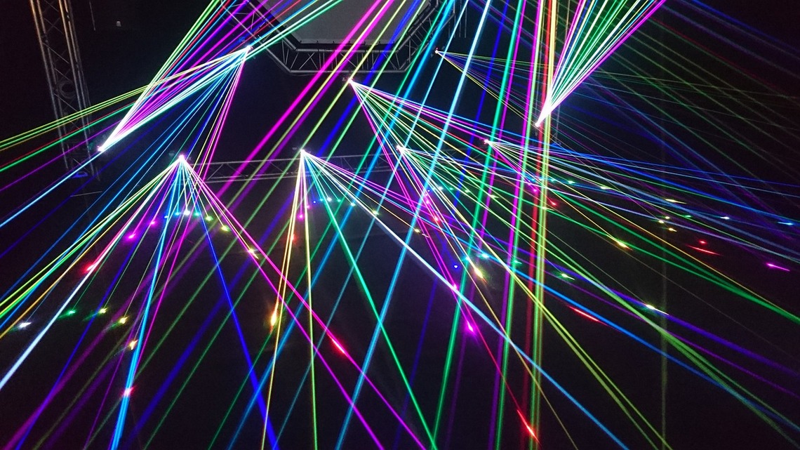 Multicoloured laser beams lighting up a dark sky