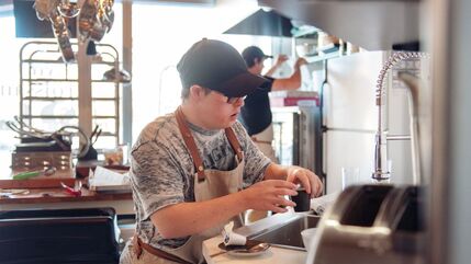 young man with learning disabilities working in a kitchen