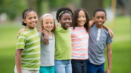 smiling group of 5 children in a park